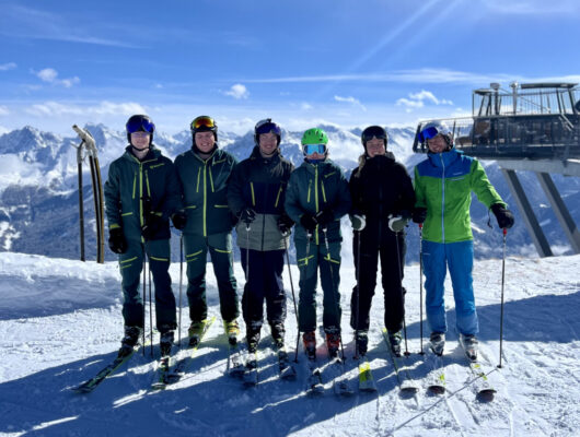 Foto von sechs Übungsleitern auf einem Berg, Skilift im Hintergrund